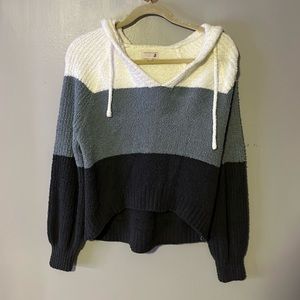 This is a off the shoulder sweater that has a hood on the back.